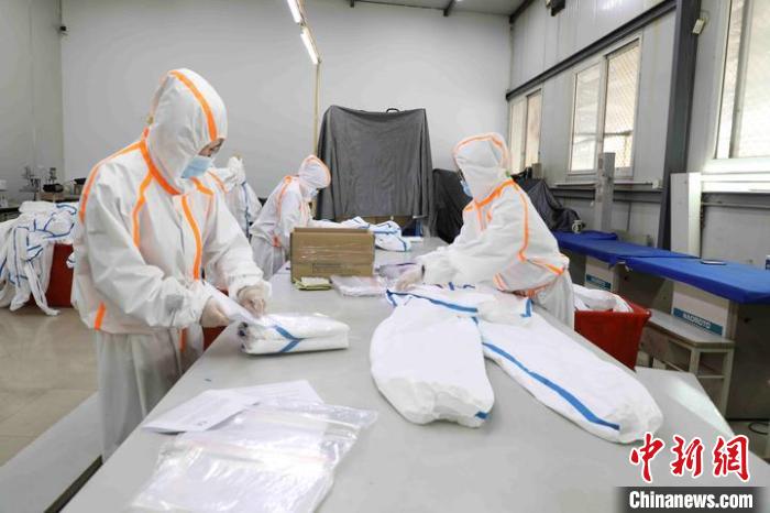 工人正在包装生产好的防护服和隔离衣。　鹿城宣传部供图 摄