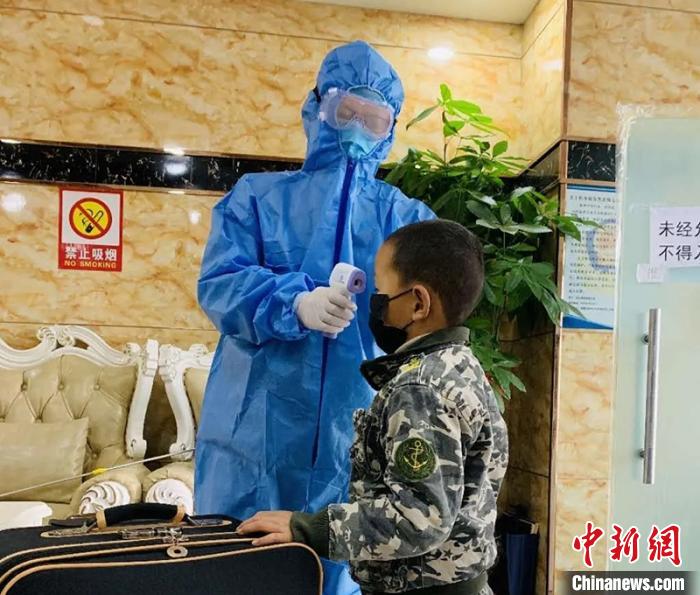 王宏权为进入集中医学观察点的人员测量体温。　受访者供图 摄
