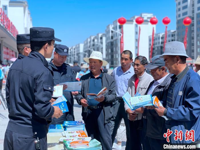 图为公安民警为当地居民讲解防电信诈骗。　孙睿 摄
