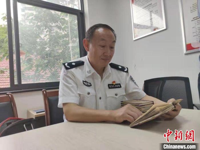 图为，民警杨远高翻看过去侦办案件笔记 孙逊 摄