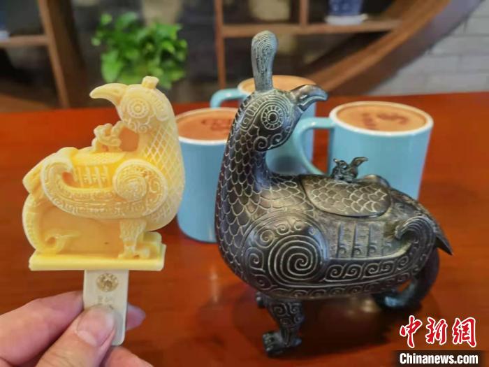 山西博物院镇馆之宝造型的“鸟尊”雪糕，旁边为鸟尊青铜器模型。　胡健 摄